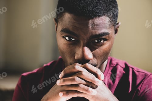 Preview: Close up young black man staring with hands clasp