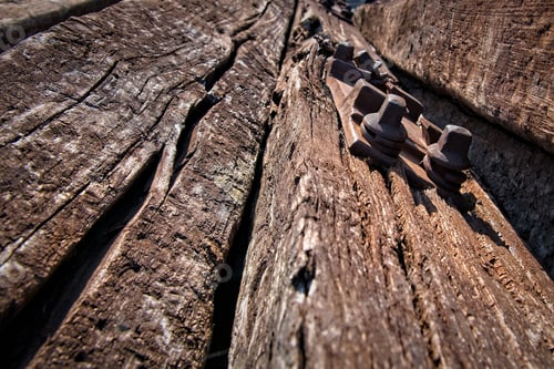 Preview: An abandoned old railway tie with a rusty bolt