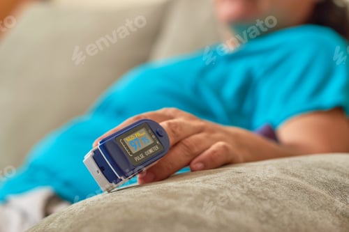 Preview: Mature woman checking her oxygenation with an oximeter from home.