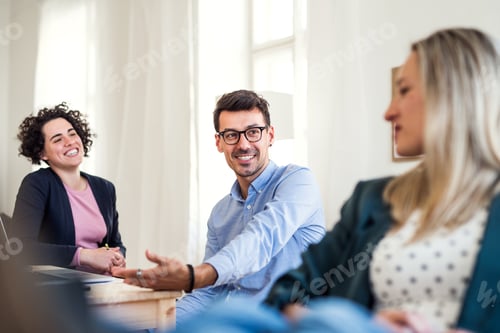 Preview: Group of young businesspeople working together in a modern office.