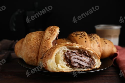 Preview: Tasty croissants with chocolate and sesame seeds on wooden table, closeup