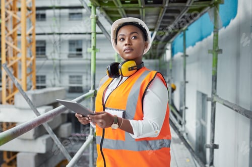 Preview: Shot of a young woman using a digital tablet while working at a construction site