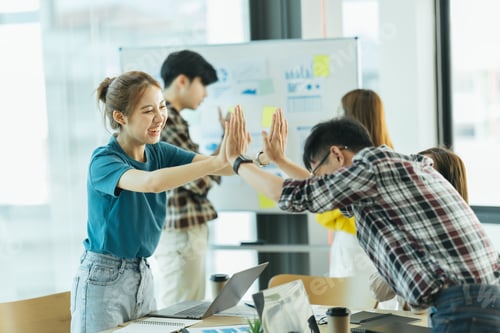 Preview: happy employees giving each other a high five.