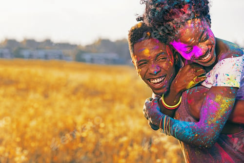 Preview: laughing african american couple piggybacking at holi festival in wheat field