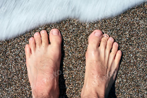 Preview: Man standing on the shore of the sea barefoot