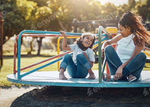 Preview: Shot of a mother and her daughter playing together on a merry-go-round at the park