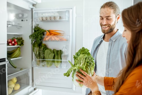 Preview: Vegan couple with fresh vegatables at the kitchen