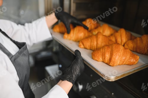 Preview: Baker taking freshly baked croissants out of oven