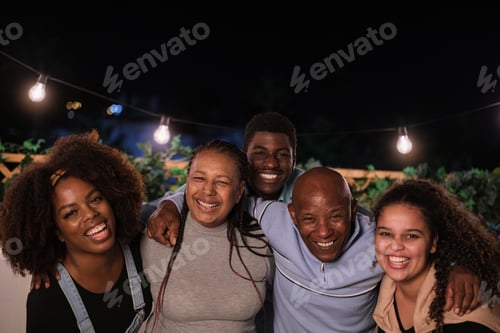 Preview: Portrait of family smiling and enjoying an evening outdoors on their terrace. Concept: family, fun