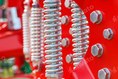 Preview: Hard spring made of steel. Part and detail of red industrial or agricultural machine