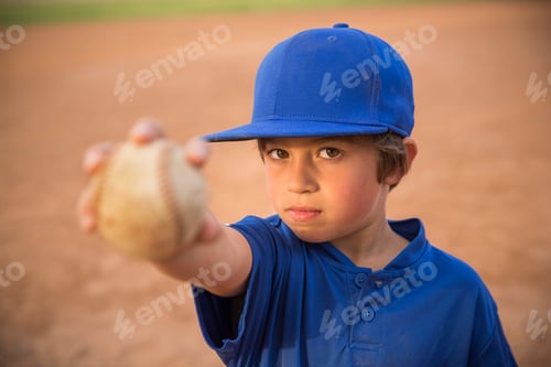 Preview: Portrait of boy holding up ball at baseball practise