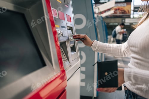 Preview: Woman's hand inserting a ticket in the urban public transport card recharging machine.