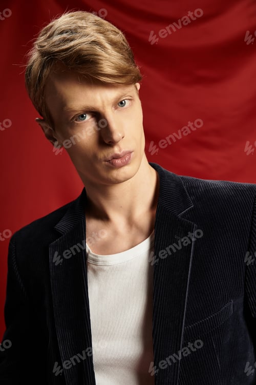 Preview: Young man showcasing modern masculinity in stylish attire against a vibrant backdrop