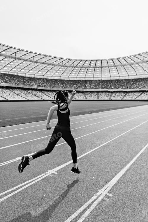 Preview: Back view of young fitness woman in sportswear sprinting on running track stadium, black and white