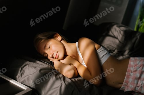 Preview: Teenager Caucasian Girl Lies on a Bed on a Pillow with her Palms under her Head