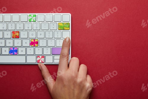 Preview: Cropped view of woman with computer keyboard with presents on buttons on red background, online