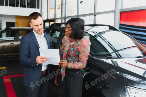 Preview: beautiful young african woman buying a car at dealership