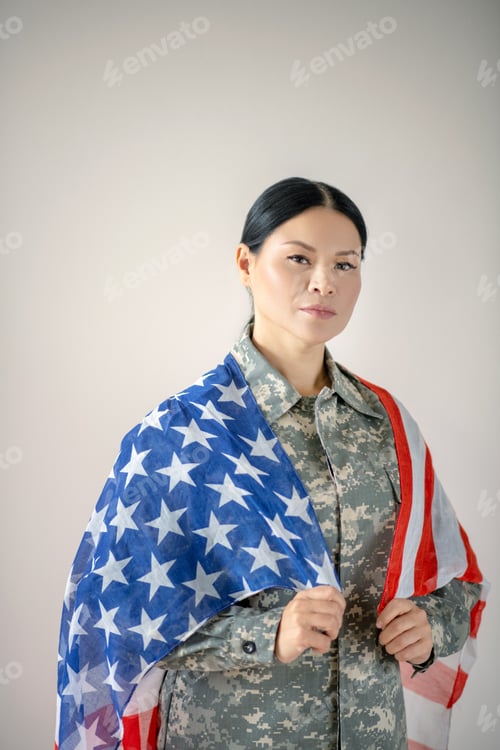Preview: Dark-eyed beautiful military woman holding American flag