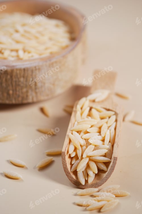 Preview: brown long rice in a wooden spoon on table .