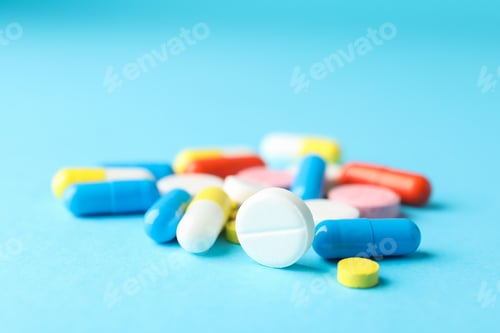 Preview: Many pills on blue background, closeup and space for text