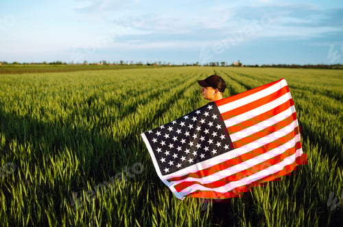Preview: Man hold waving american USA flag. Patriot raise national american flag. Independence Day, 4th July.