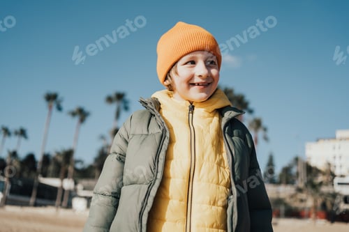 Preview: Portrait of happy laughing child boy on the beach. Kid smiling outdoors on the autumn winter beach.