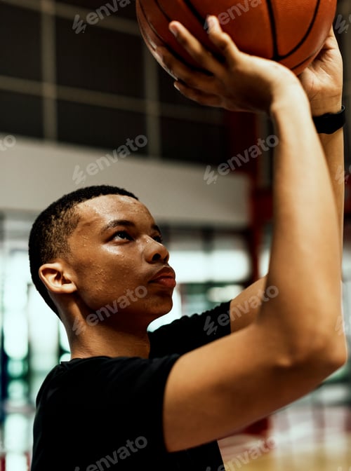 Preview: African American teenage boy concentrated on playing basketball