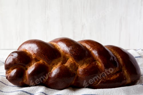 Preview: Homemade jewish challah bread on a white wooden background, side view. Closeup.
