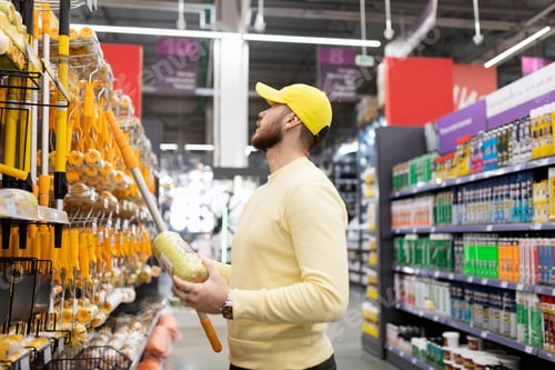 Preview: Builder picking up a new roller for painting work in an interior goods store