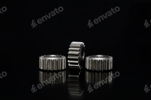 Preview: Ecorative shot with three cogwheels on a black background.