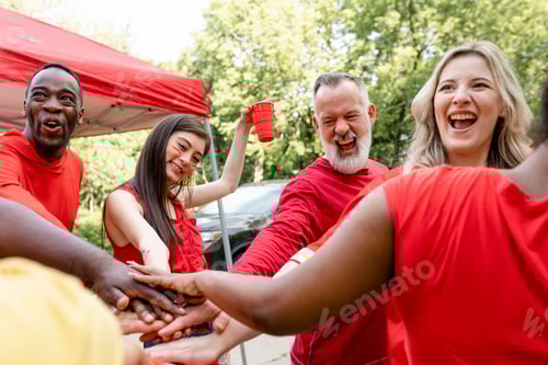 Preview: Sports fans in a huddle at a tailgate event