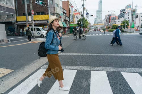 Preview: girl tourist walking through crosswalk in Osaka