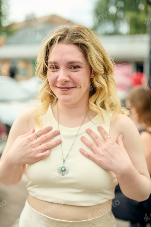 Preview: Young woman smiling outdoors in soft natural light