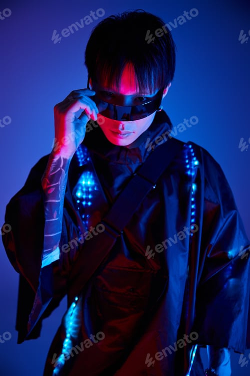 Preview: Stylish young man in neon lights showcasing modern fashion and confidence at an urban setting
