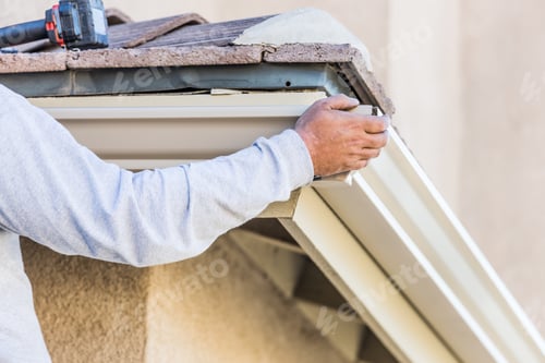 Preview: Worker Attaching Aluminum Rain Gutter to Fascia of House