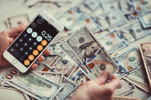 Preview: Millennial candid authentic man close up hand counting 100 US dollars banknotes using calculator