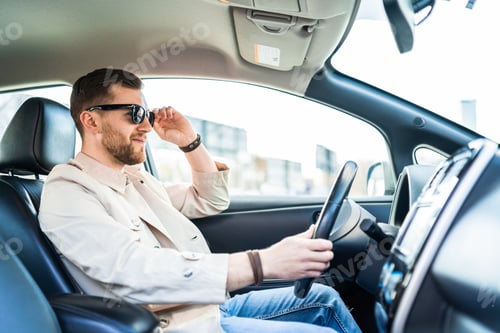 Preview: Stylish man in sunglasses driving car