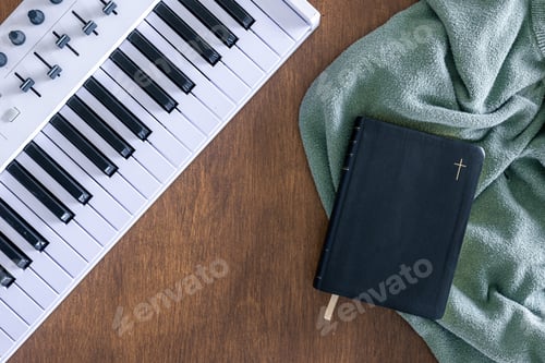 Preview: Synthesizer keys, bible and plaid on a wooden background, top view.