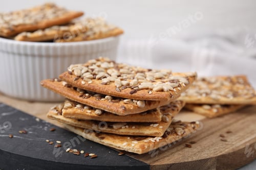Preview: Cereal crackers with flax, sunflower and sesame seeds on board, closeup