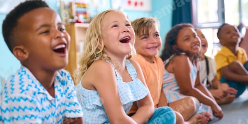 Preview: Line Of Smiling Primary Or Elementary School Students Sitting On Floor During Classroom Lesson