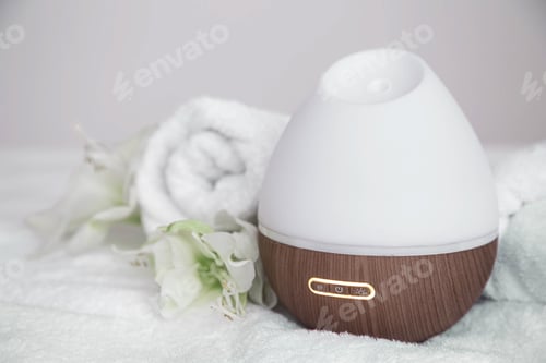 Preview: Spa composition with aroma diffuser and towel on a blurred background.