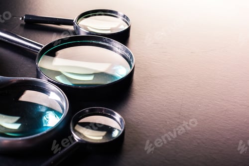 Preview: Closeup of magnifying glass on dark surface