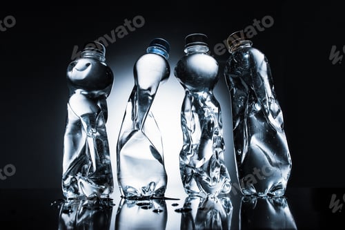 Preview: row of crumpled bottles of water on dark