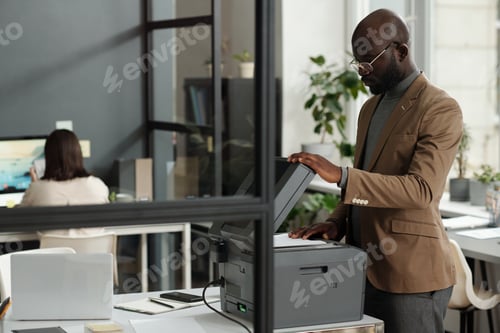 Preview: Confident young male chief executive officer making copies of documents