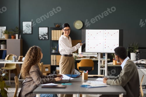 Preview: Caucasian Woman Explaining Data Trends to Diverse Colleagues in Office