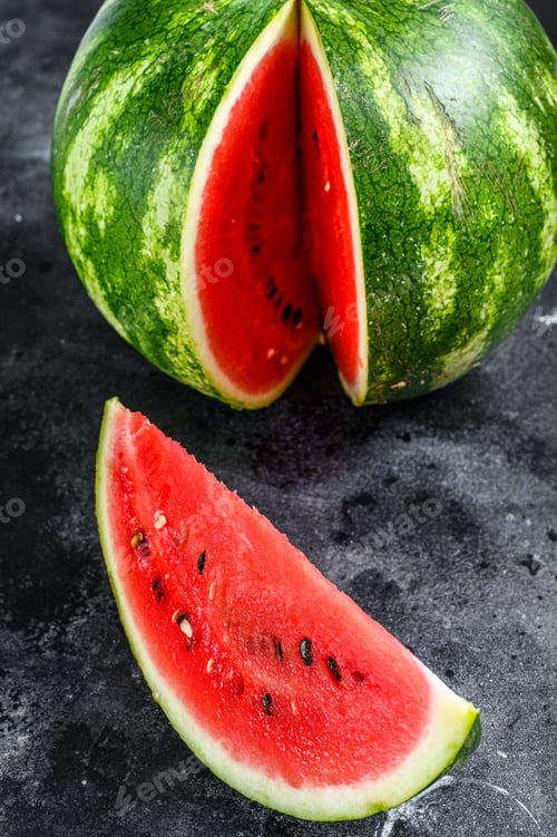 Preview: Red ripe watermelon with cut-out slices. Black background. Top view