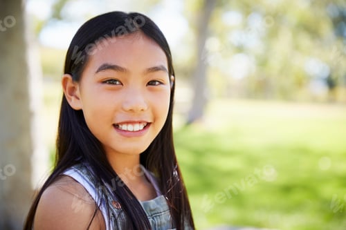 Preview: Young Asian schoolgirl smiling to camera, close up