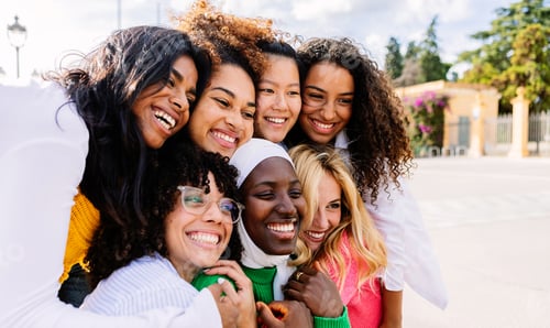 Preview: Group of diverse young girls smiling together outdoors.