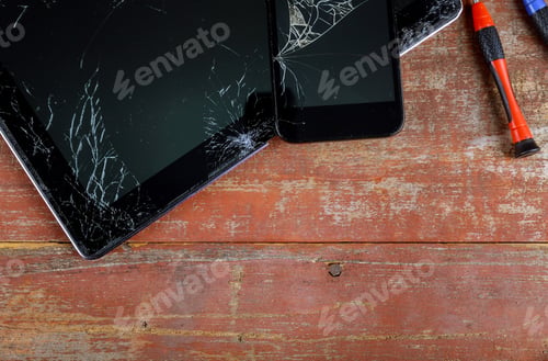 Preview: Repair tablet and smart phone with broken touch screen on wooden desk