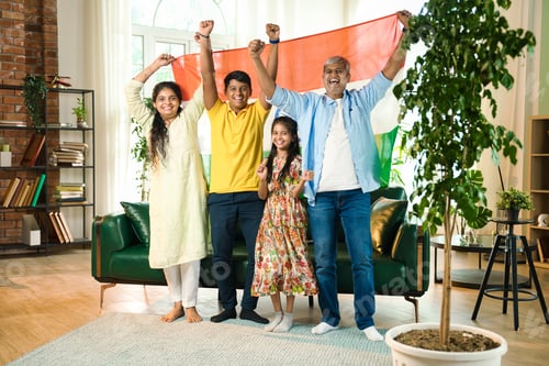 Preview: Indian family celebrating victory on TV, waving the tricolor flag joyfully from their sofa
